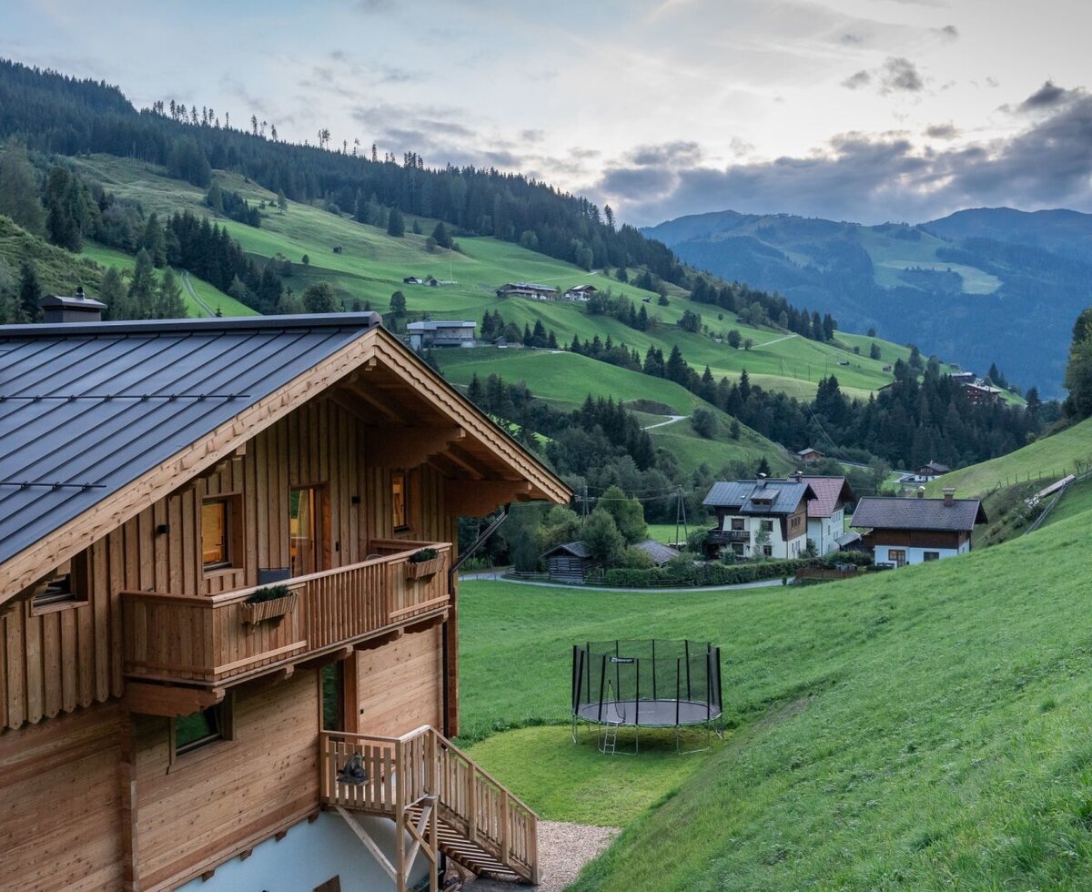 Der Bauernhofliegt inmitten einer idyllischen Berglandschaft mit grünen Wiesen und einem hauseigenen Trampolin im Garten.