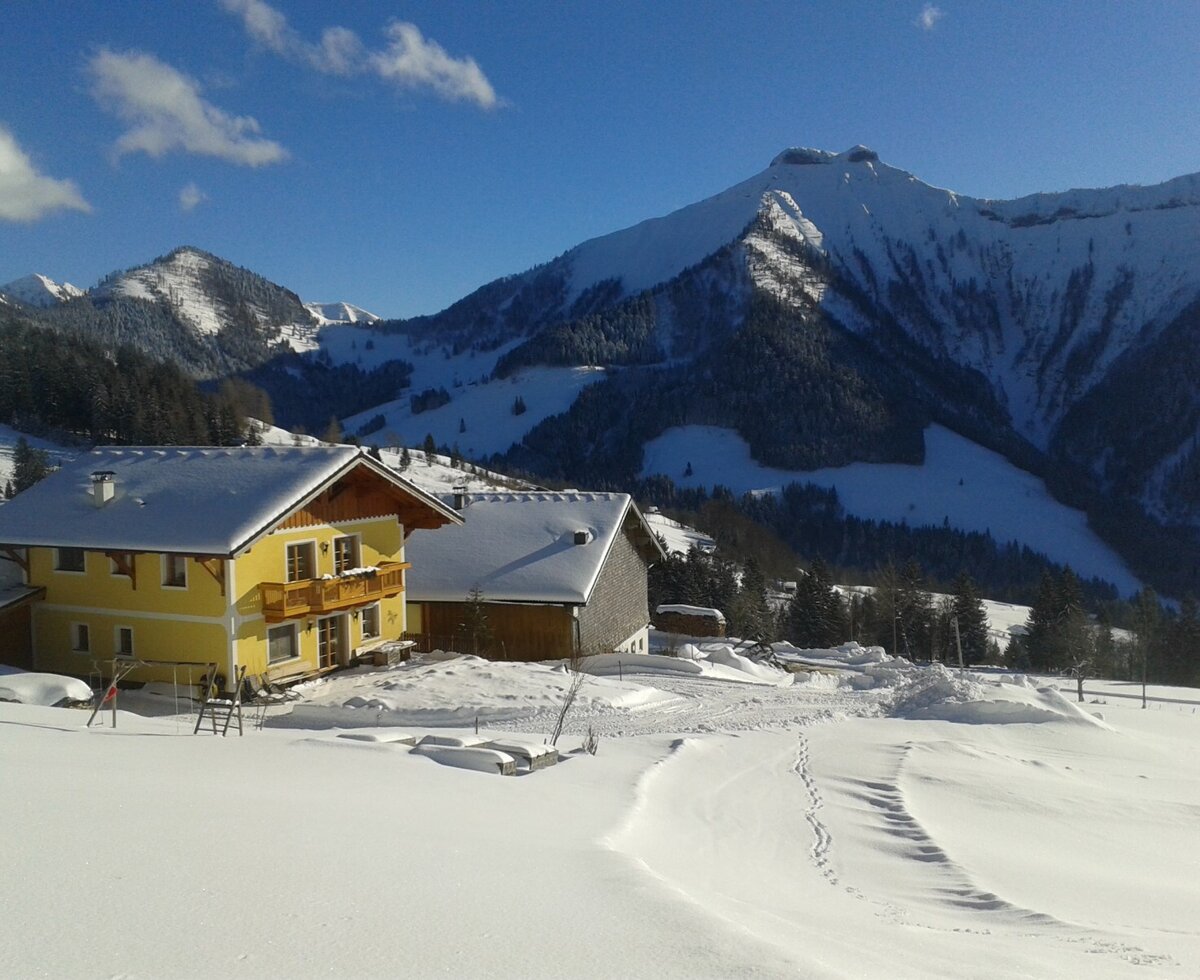 Der Bauernhof Reitlhof in der verschneiten Berglandschaft.