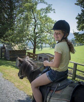Ponyreiten für Kinder auf dem Bauernhof.