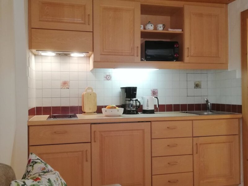 Die Küchenzeile im Bauernhof verfügt über Holzschränke, ein Kochfeld, eine Mikrowelle, eine Kaffeemaschine und einen Wasserkocher.