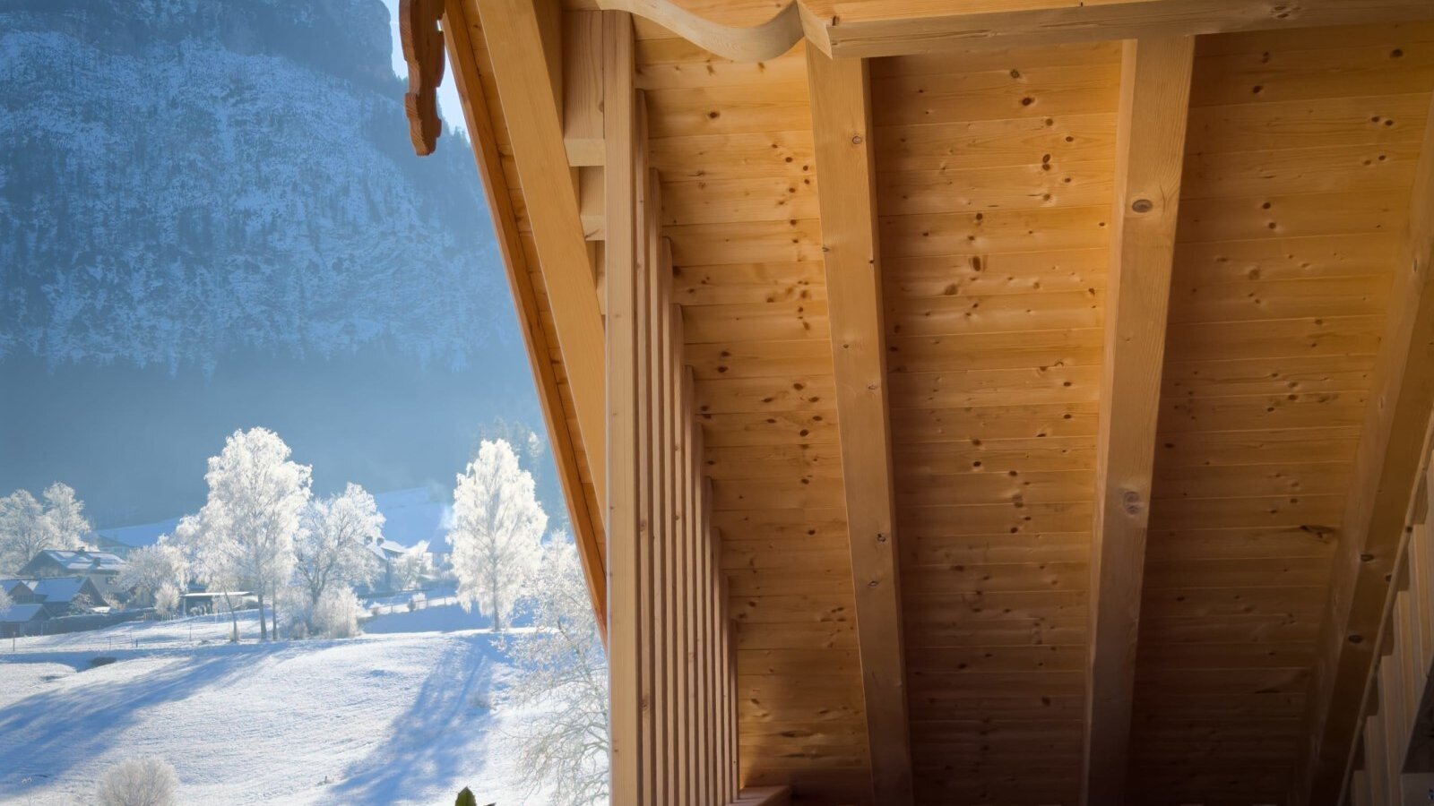 Whirlpool auf dem Holzbalkon des Bauernhofs mit Blick auf die verschneite Berglandschaft.