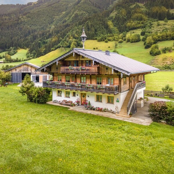 Der einladende Bauernhof inmitten von saftig grünen Wiesen und einer malerischen Bergkulisse.