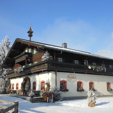 Der Bauernhof "Stefflhof" in winterlicher Umgebung mit traditioneller Architektur und Balkonen.