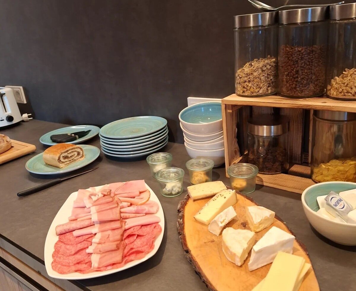 Frühstücksbuffet im Bauernhof mit Aufschnitt, Käse, Mohnstrudel und Müsli.