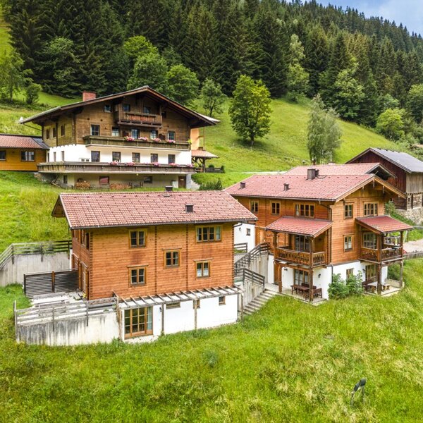 Der einladende Bauernhof liegt inmitten von saftig grünen Wiesen und bewaldeten Berghängen.