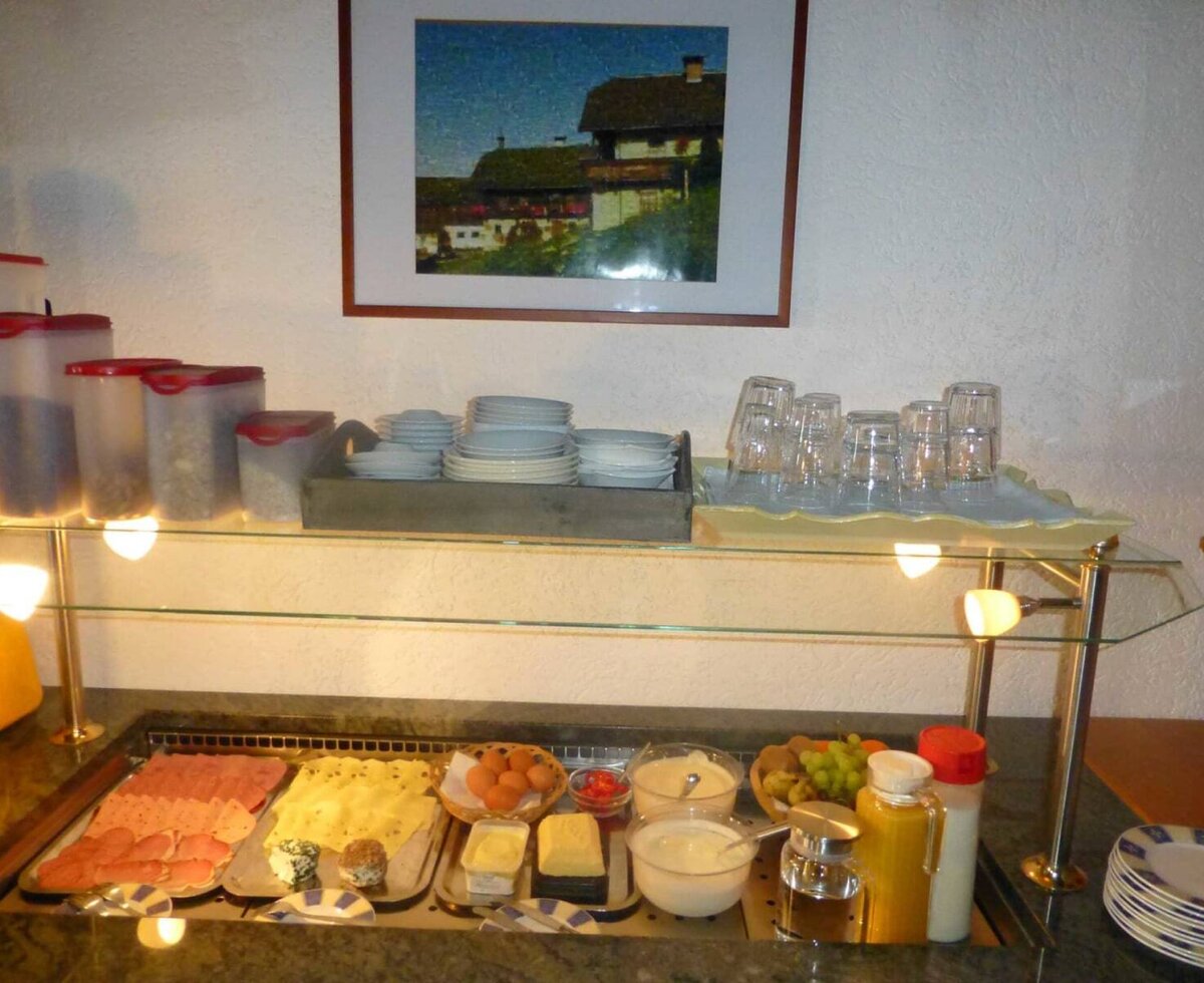 Frühstücksbuffet der Ferienwohnung mit Aufschnitt, Käse, Eiern, Müsli, Joghurt, Obst und Getränken.