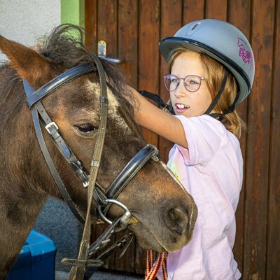 Liebevoller Kontakt mit den Ponys direkt an der Ferienwohnung – ein tolles Erlebnis für kleine Gäste.