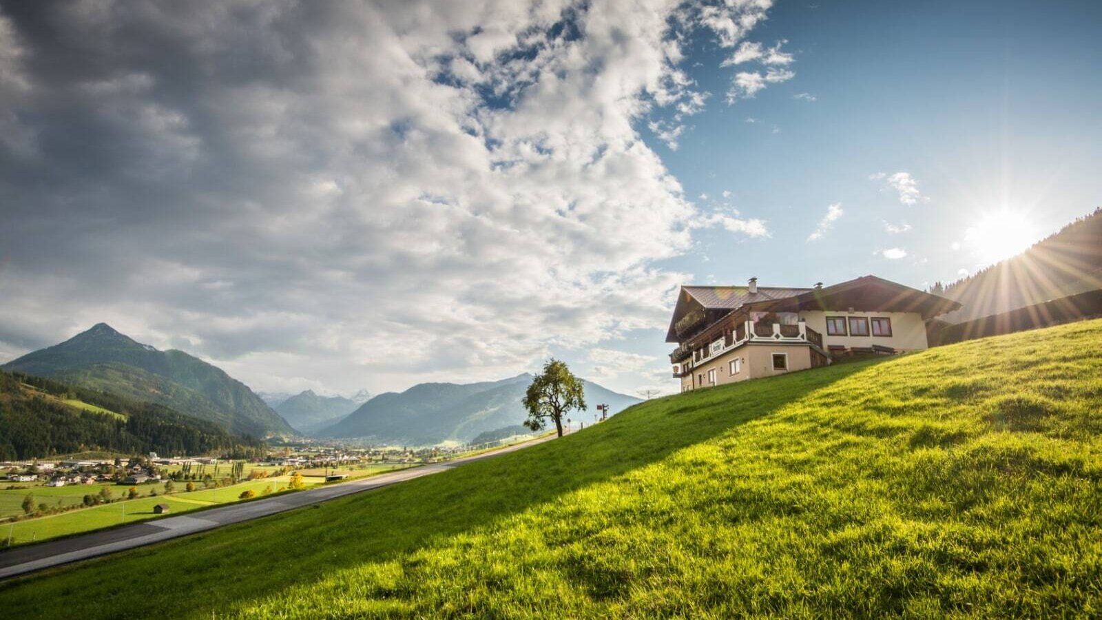 Das Bed and Breakfast auf einem grünen Hang mit Blick auf das Tal und die Berge.