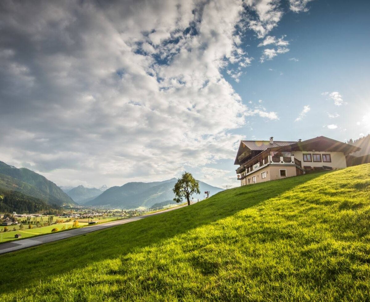 Das Bed and Breakfast auf einem grünen Hang mit Blick auf das Tal und die Berge.
