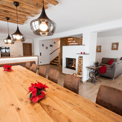 Der Essbereich des Hofes mit langem Holztisch, Sitzbank, Stühlen, integrierter Küche und Kamin.