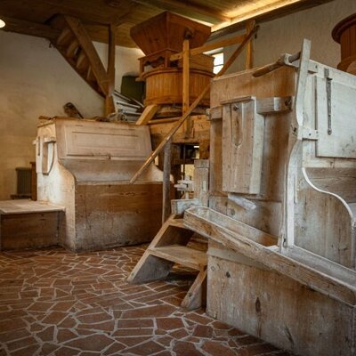 Historische Mühlenanlage aus Holz im Bed and Breakfast, mit Treppen und Fliesenboden.