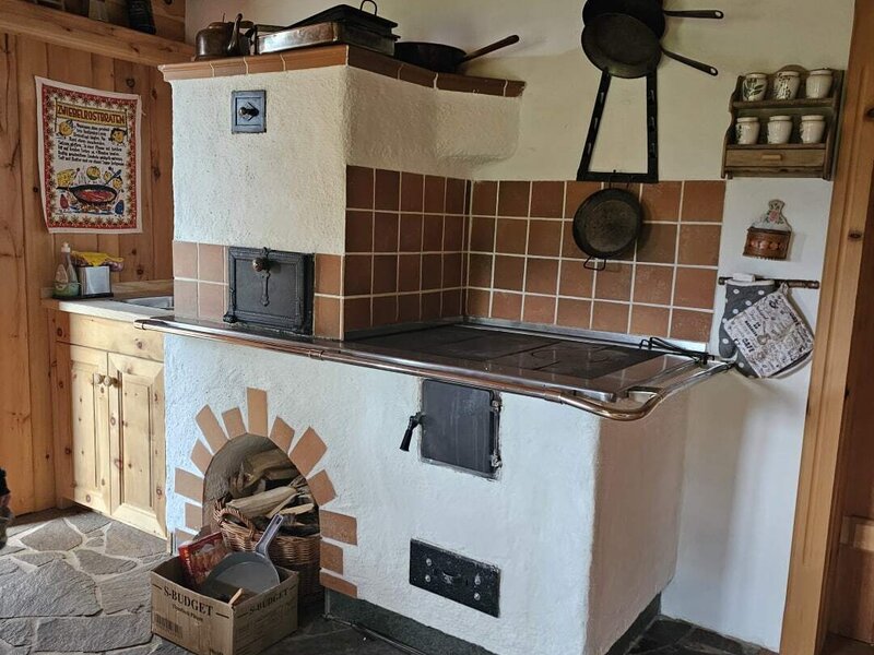 Die traditionelle Küche des Bed and Breakfast mit einem Holzofen, Backfach und Steinboden.