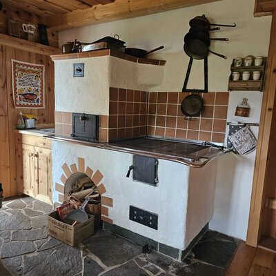 Die traditionelle Küche des Bed and Breakfast mit einem Holzofen, Backfach und Steinboden.
