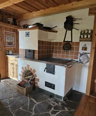 Die traditionelle Küche des Bed and Breakfast mit einem Holzofen, Backfach und Steinboden.