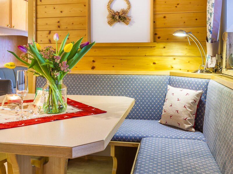 Essecke im Bauernhof mit Holztisch und gepolsterter Eckbank, ausgestattet mit Holzvertäfelung.