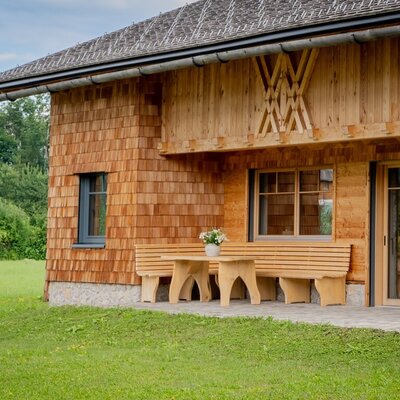 Der Bauernhof bietet eine Terrasse aus Holz mit Tisch und Bänken.