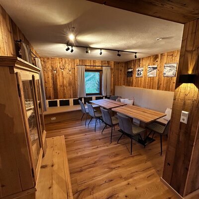 Gemeinschafts- und Essbereich im Hof mit Holztischen, Bänken und Holzwänden.