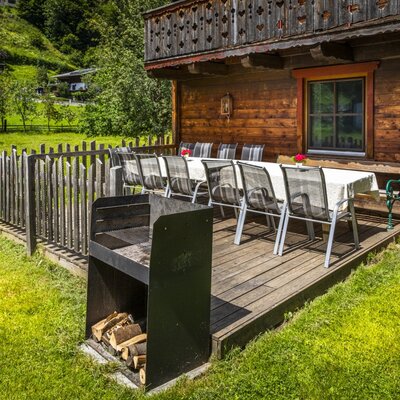 Die Terrasse des Hofes mit großem Gartentisch, Stühlen und Grill bietet direkten Zugang zur Rasenfläche.