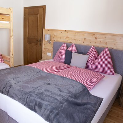 Schlafzimmer im Bauernhof mit Doppelbett und Etagenbett.