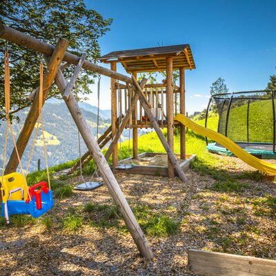 Der Spielplatz am Bauernhof verfügt über Schaukeln, eine Rutsche, einen Sandkasten und ein Trampolin.