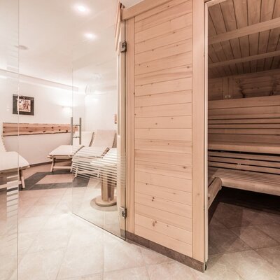 Saunabereich des Bauernhofs mit Holzsauna und Ruheraum mit Liegestühlen.