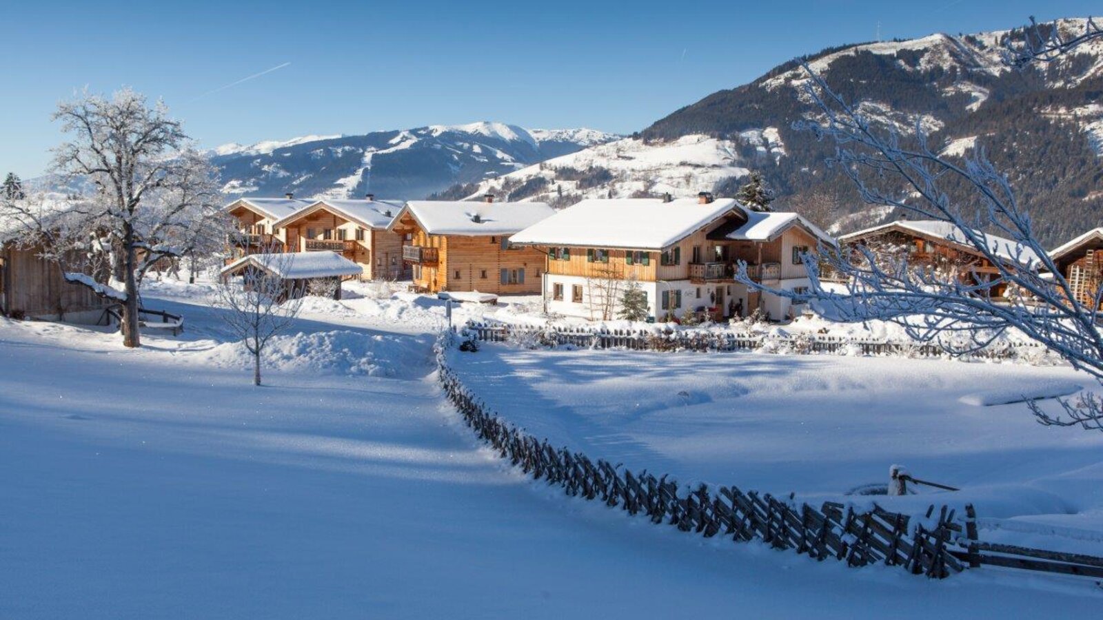 Die verschneiten Gebäude des Bauernhofs inmitten der winterlichen Berglandschaft.