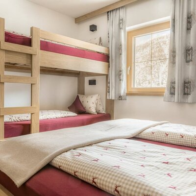 Schlafzimmer mit einem Etagenbett und einem Doppelbett.