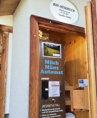 Der hofeigene Milchautomat des Bauernhofs bietet rund um die Uhr frische, gekühlte Bio-Heumilch.
