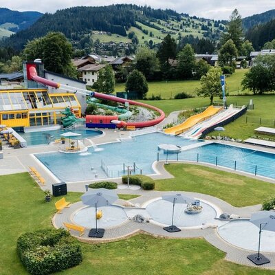Die Außenbadeanlage mit mehreren Pools, Wasserrutschen und Liegewiesen bietet Erholung für Gäste des Bauernhofs.