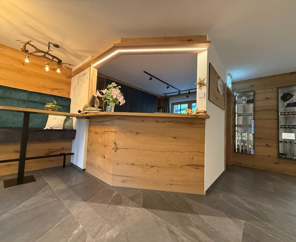 Der Empfangsbereich des Bauernhofs mit Holztheke, Sitzbank und Auslagen.