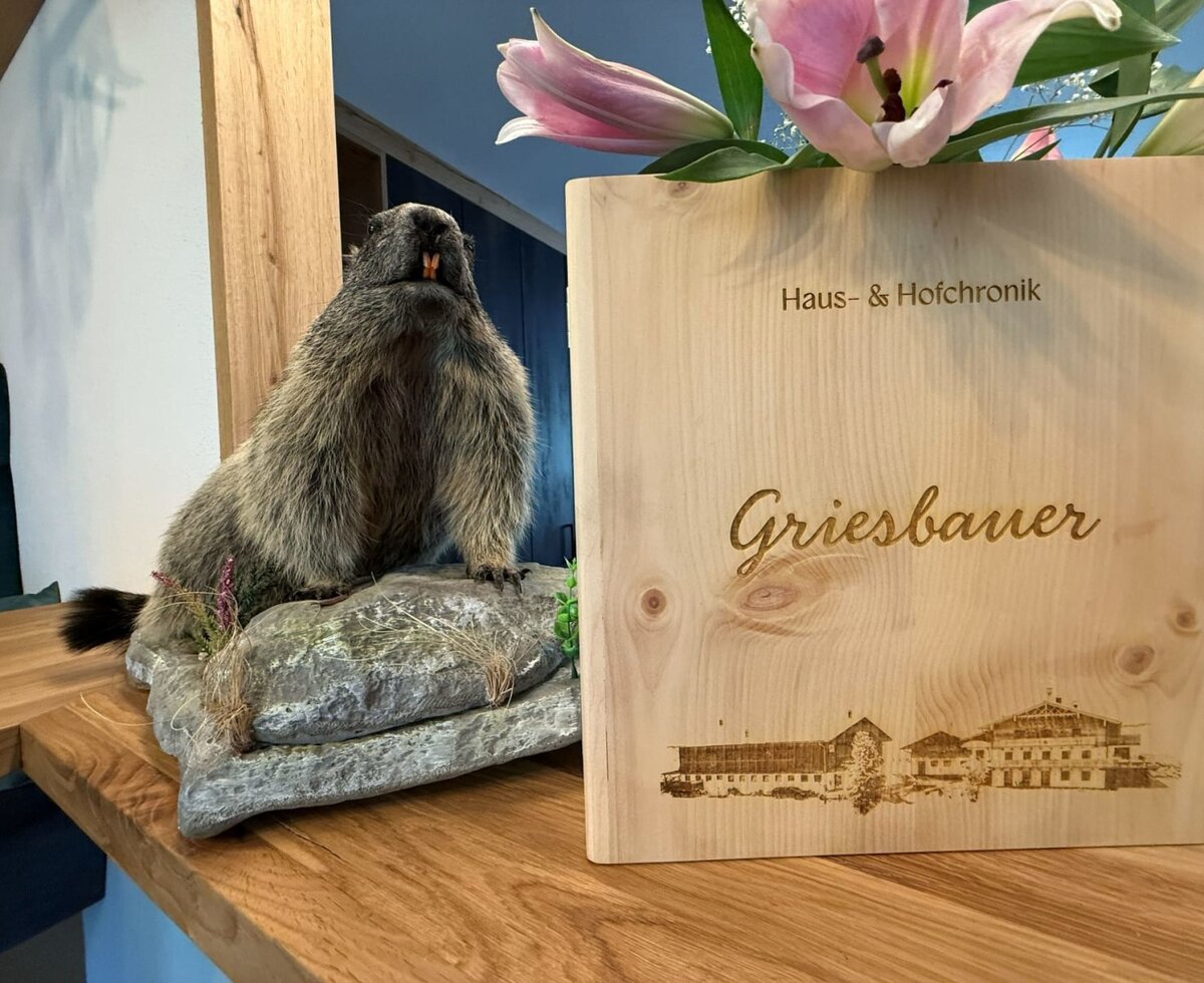 Haus- & Hofchronik des Bauernhofs Griesbauer, ein Holzmappe mit Gravur und Murmeltier-Dekoration.
