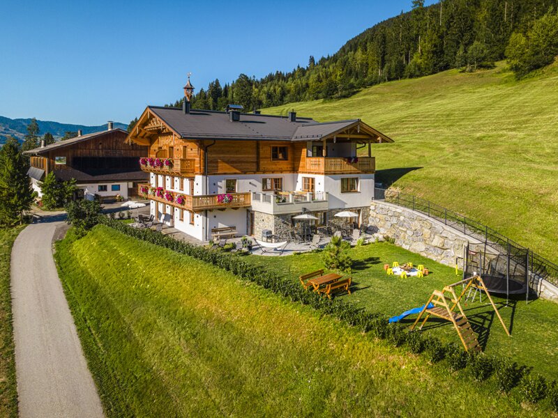 Der einladende Bauernhof besticht durch einen weitläufigen Garten mit Kinderspielplatz und einer sonnigen Terrasse inmitten grüner Natur.