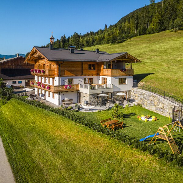 Der einladende Bauernhof besticht durch einen weitläufigen Garten mit Kinderspielplatz und einer sonnigen Terrasse inmitten grüner Natur.