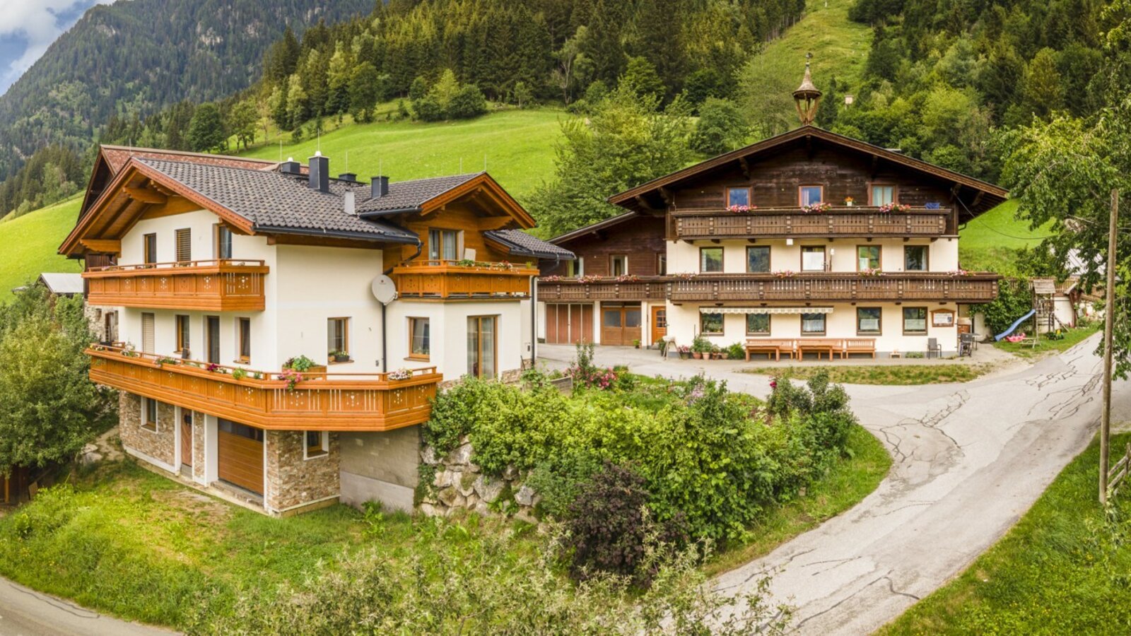 Der einladende Bauernhof im traditionellen Stil, umgeben von grünen Wiesen und dichten Wäldern.