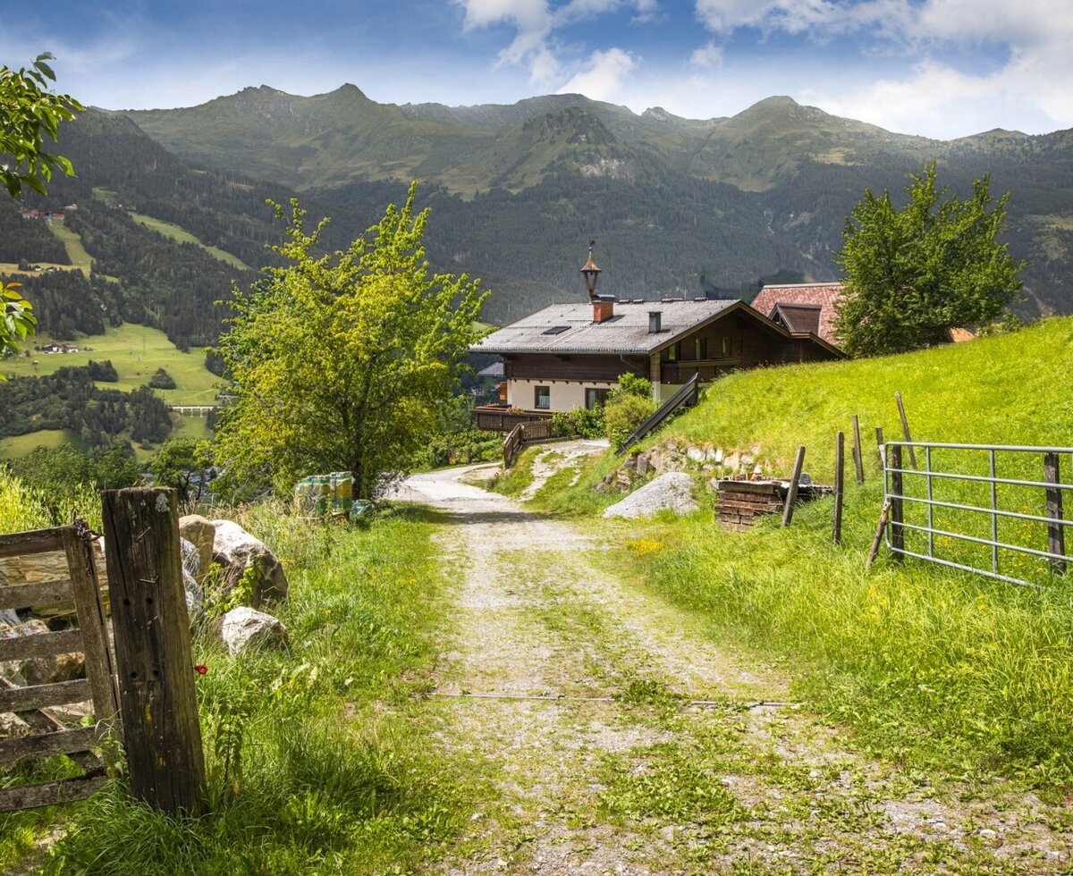 Der idyllische Bauernhof eingebettet in saftig grüne Wiesen mit herrlichem Blick auf die umliegende Berglandschaft.