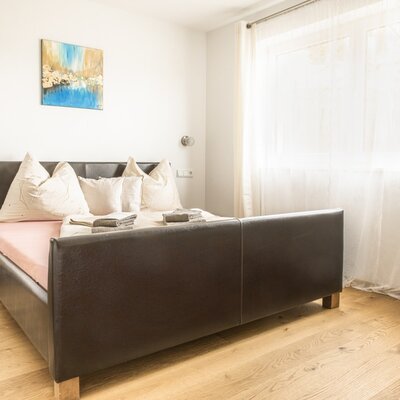 Schlafzimmer im Bed and Breakfast mit Doppelbett, Holzboden und Nachttisch.