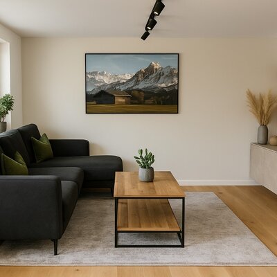 Das Wohnzimmer des Bed and Breakfast bietet ein dunkles L-förmiges Sofa, einen Holztisch und einen Fernseher.