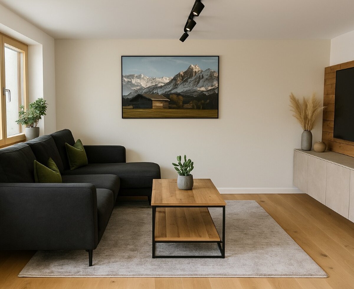 Das Wohnzimmer des Bed and Breakfast bietet ein dunkles L-förmiges Sofa, einen Holztisch und einen Fernseher.