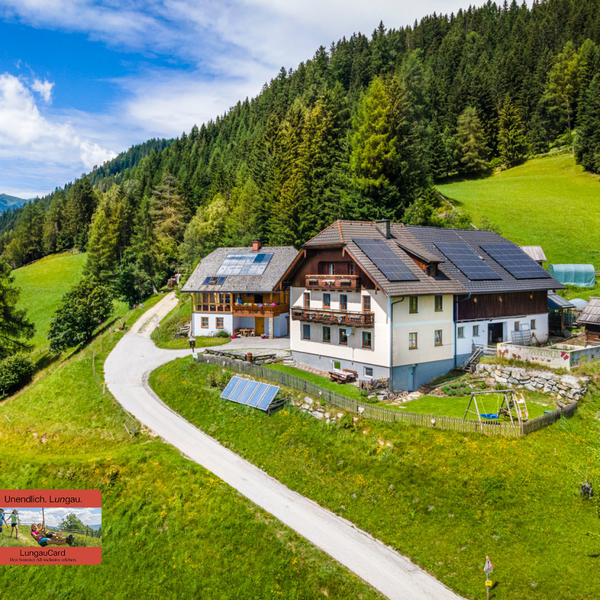 Krametergut im Sommer mit UaB Logo und Lungaucard