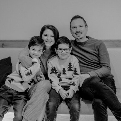 Eine Familie mit zwei Kindern sitzt auf einer Bank im Bauernhof.