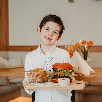 Unser Louis präsentiert einen Burger mit Pommes frites
