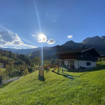 Außenansicht vom Ferienhaus mit Spielplatz und großer Terrasse.