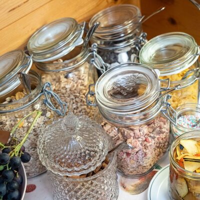 Das Frühstücksbuffet des Bed and Breakfast mit einer Auswahl an Müslis, Cerealien und frischem Obst.