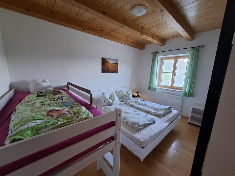 Schlafzimmer in der Ferienwohnung mit Doppelbett, Hochbett für Kinder und Blick ins Grüne