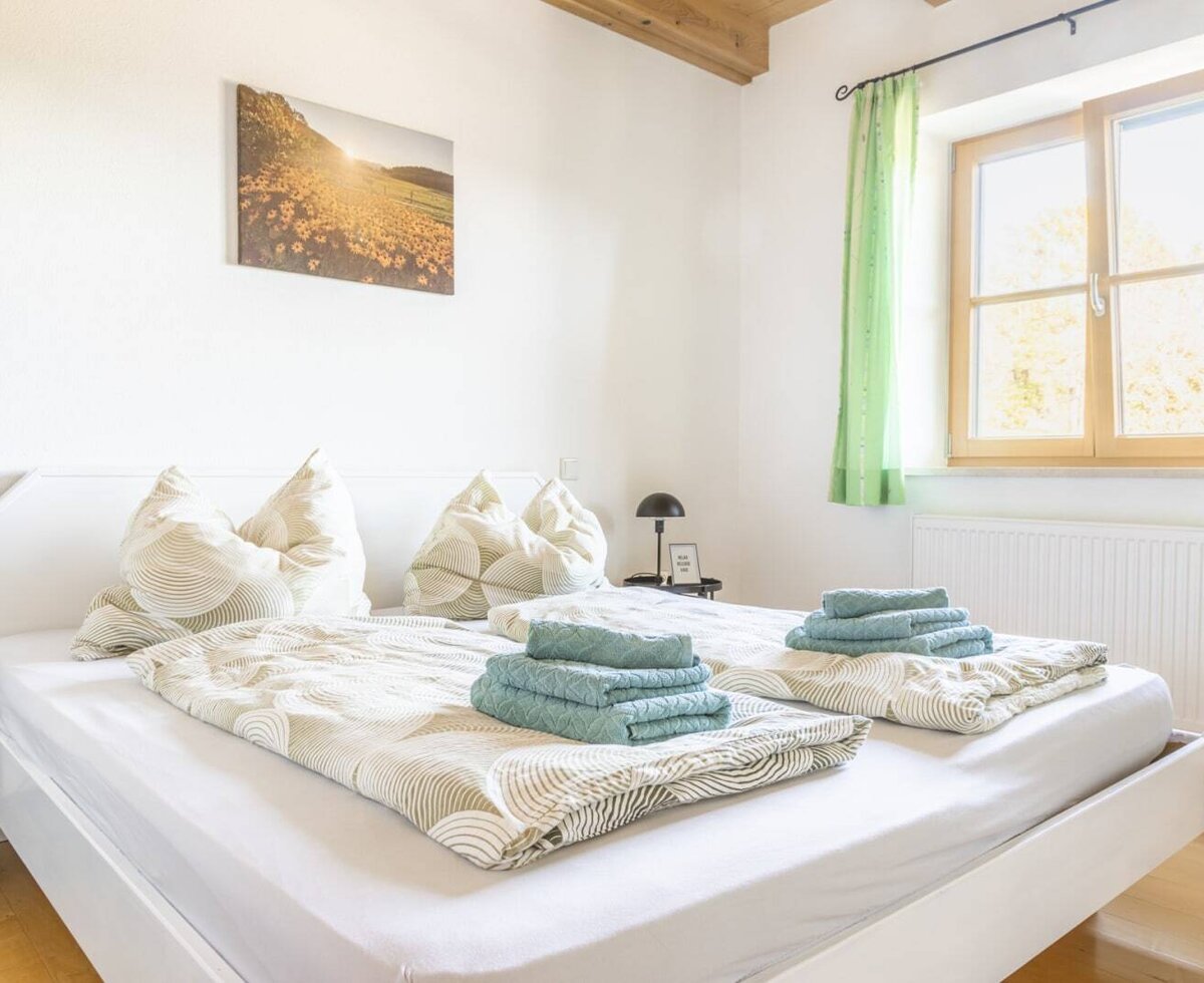 Ein gemütliches Doppelzimmer auf dem Bauernhof mit einladendem Doppelbett, frischen Handtüchern und hellem, natürlichem Licht.