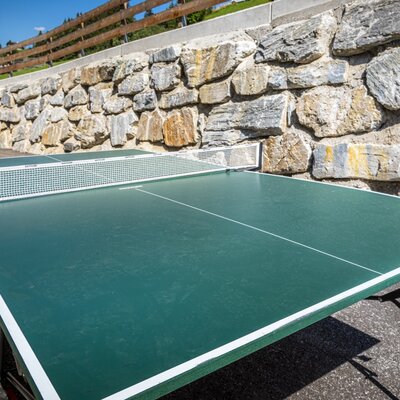 Die Tischtennisplatte des Bauernhofs im sonnigen Außenbereich lädt zu einer Partie an der frischen Luft ein.