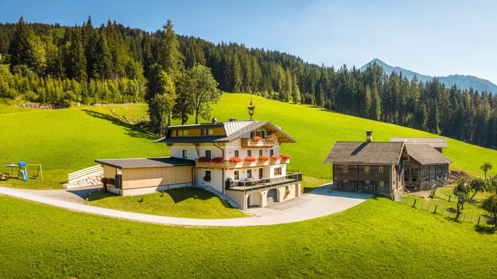 Der einladende Bauernhof Peterlehen in ruhiger, sonniger Hanglage, umgeben von grünen Wiesen und Wäldern.