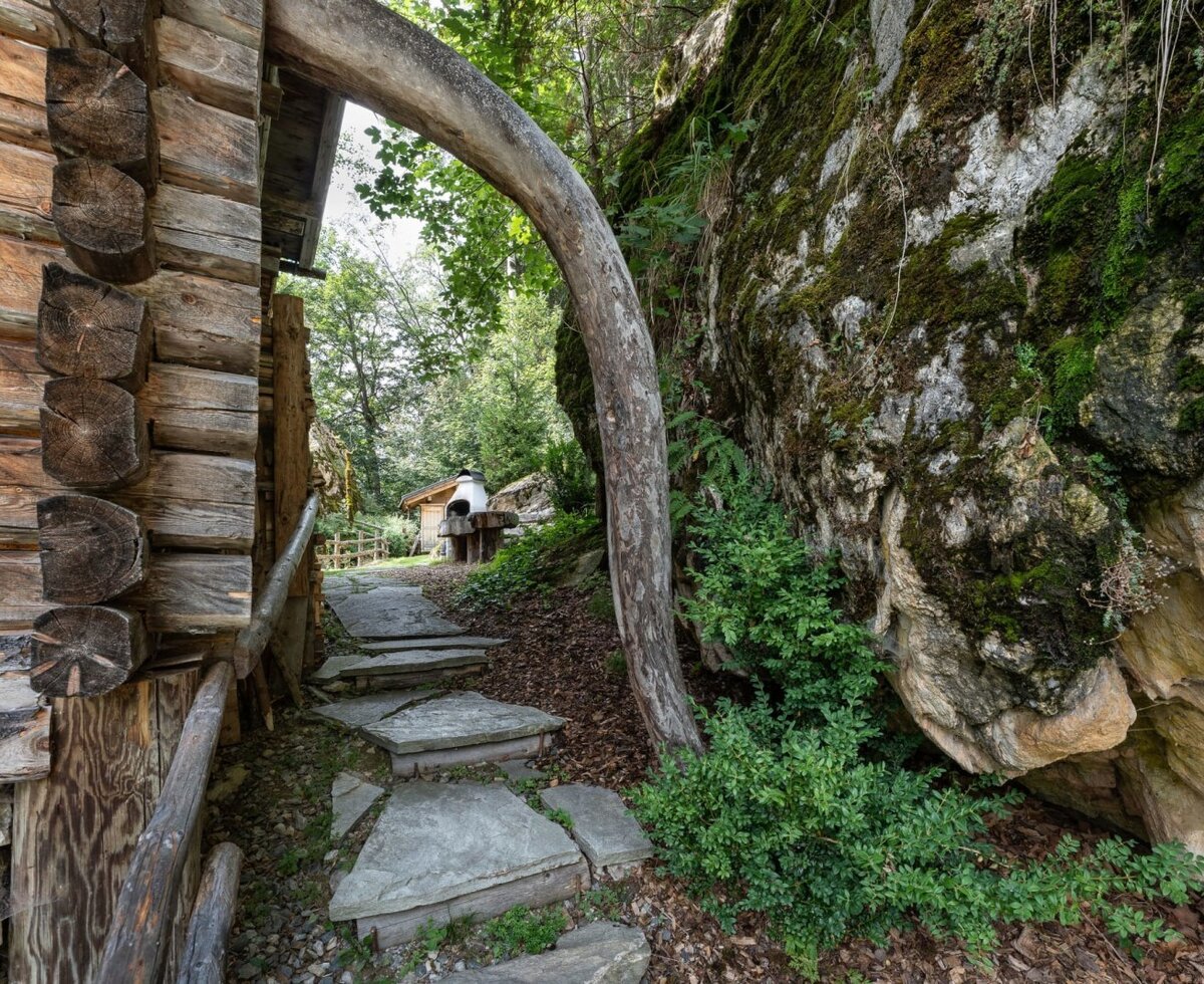 Ein uriger Steinpfad an der Seite der Alm, umgeben von natürlichen Felswänden und sattem Grün.