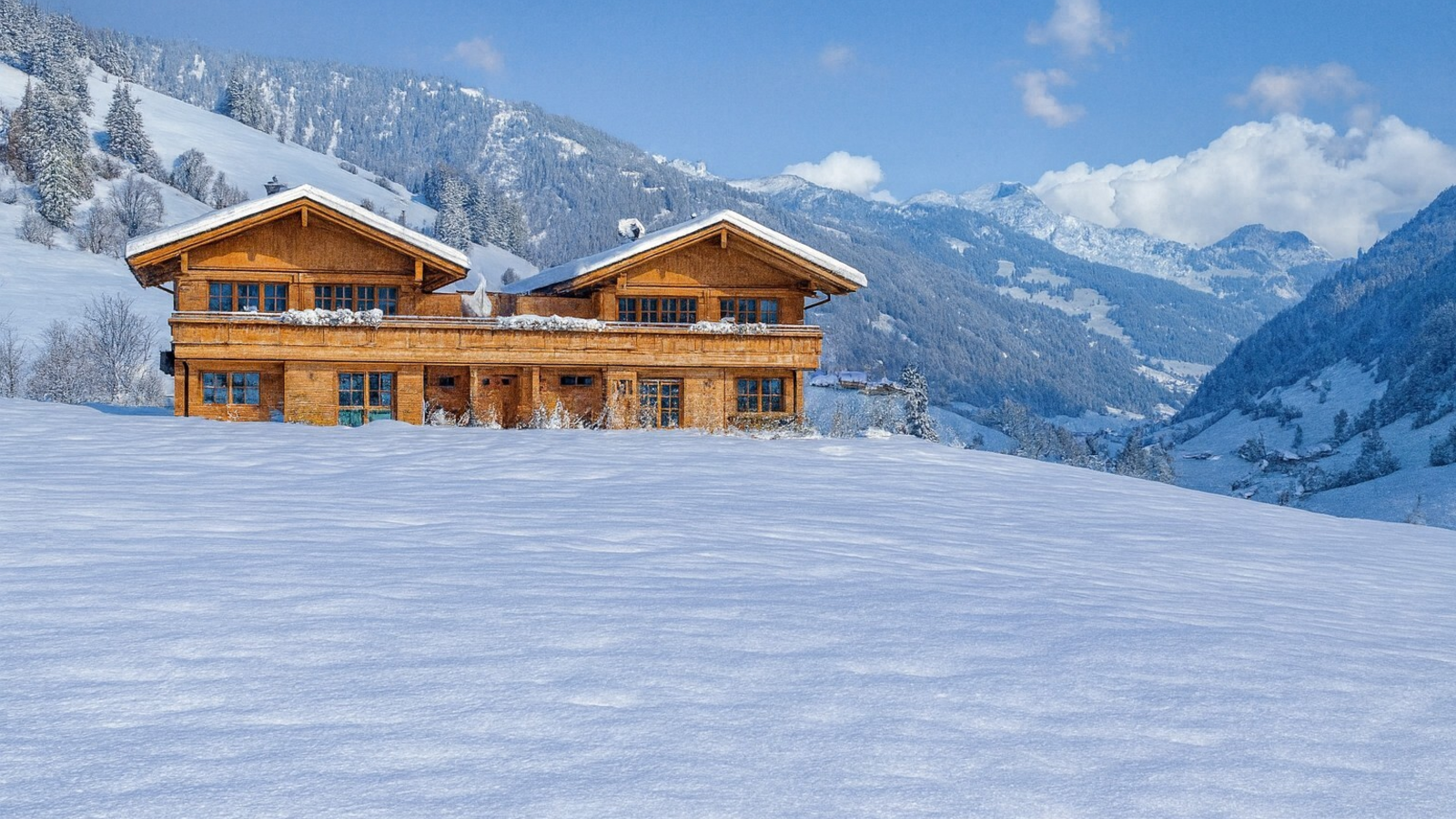 Unsere Chalets aus Holz in einer verschneiten Berglandschaft.