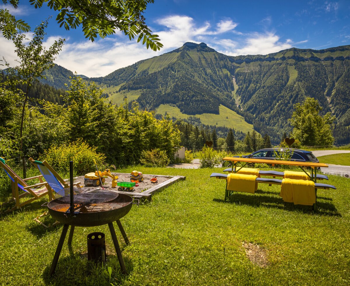 Der Garten des Bauernhofs bietet einen Grill, einen Sandkasten mit Spielzeug, Liegestühle und einen Picknicktisch mit Bergblick.